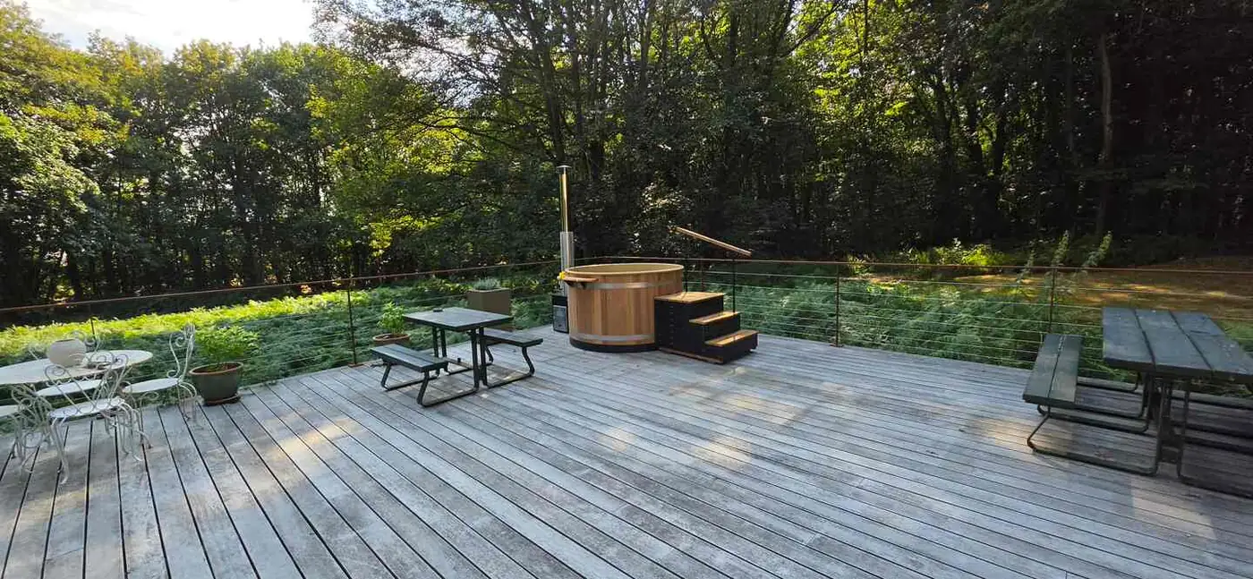 Le bain nordique en cèdre sur la terrasse, face à la forêt